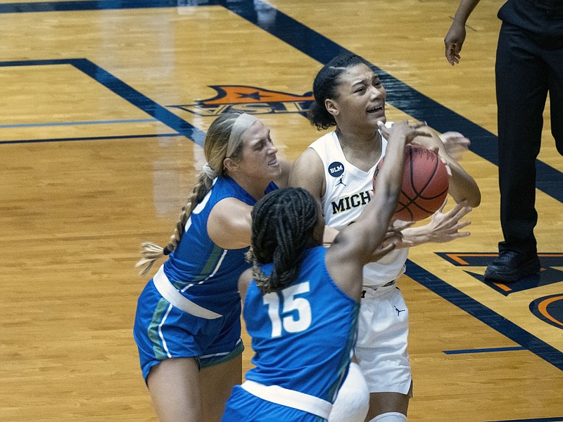 Michigan guard Naz Hilmon, right, goes up for a shot against Florida Gulf Coast guard Tyra Cox, center, and Emma List, left, during the first quarter of a college basketball game in the first round of the women's NCAA tournament at the University of Texas San Antonio Convocation Center in San Antonio, Texas, Sunday March 21, 2021. (AP Photo/Michael Thomas)
