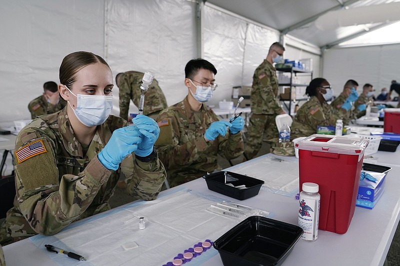 The Associated Press
In this March 9 file photo, Army health specialists fill syringes with the Pfizer COVID-19 vaccine in Miami. Despite the clamor to speed up the U.S. vaccination drive against COVID-19, the first three months of the rollout suggest faster is not necessarily better.