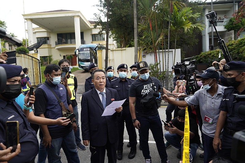 Kim Yu Song, center, a counselor at the North Korean Embassy to Malaysia, reads out a statement outside the embassy in Kuala Lumpur, Sunday, March 21, 2021. Malaysia on Friday ordered all North Korean diplomats to leave the country within 48 hours, an escalation of a diplomatic spat over Malaysia's move to extradite a North Korean suspect to the United States on money laundering charges. (AP Photo/Vincent Thian)