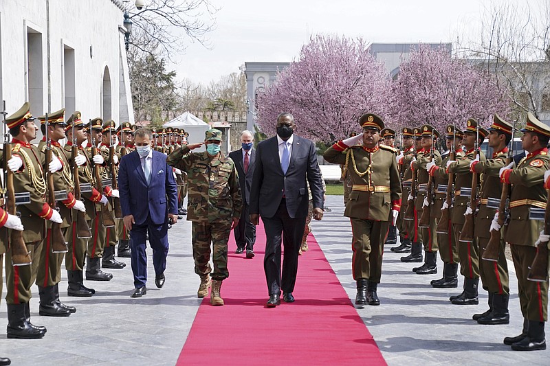 ADDS REFERENCE TO ACTING AFGHAN MINISTER OF DEFENSE YASIN ZIA - U.S. Defense Secretary Lloyd Austin, center, walks on the red carpet with Acting Afghan Minister of Defense Yasin Zia as they review an honor guard at the presidential palace in Kabul, Afghanistan, Sunday, March 21, 2021. Austin arrived in Kabul on his first trip to Afghanistan as Pentagon chief, amid swirling questions about how long American troops will remain in the country. (Presidential Palace via AP)