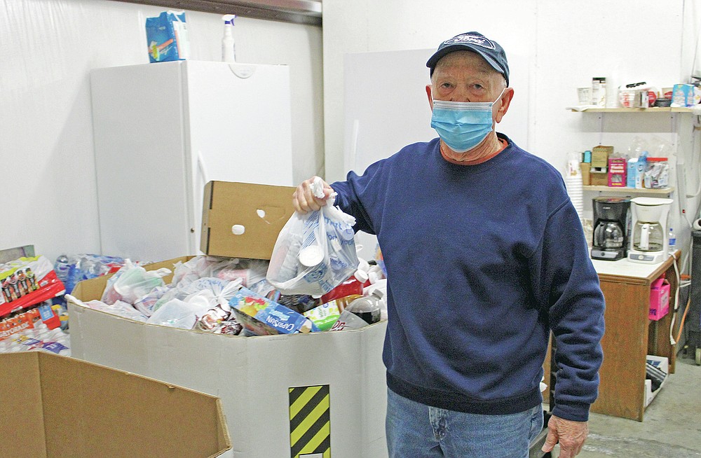 Jim Perry, director of the Faith Fellowship Food Pantry, holds a bag of drinks that will be given to the needy. (Hot Springs Sentinel-Record/Tanner Newton)