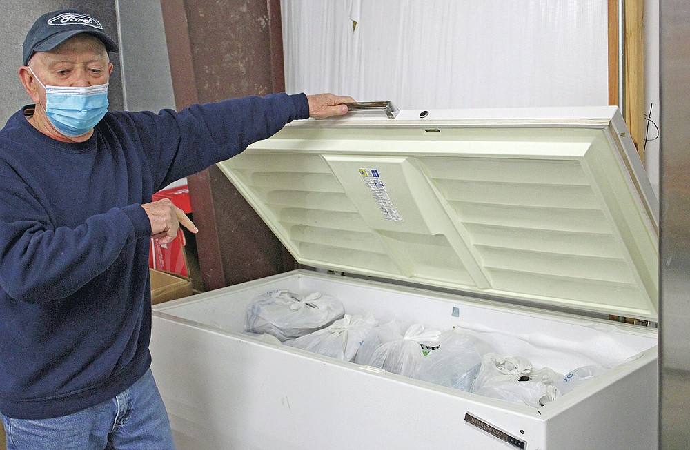 Jim Perry, director of the Faith Fellowship Food Pantry, stands in the pantry near food that will be given out to the hungry. (Hot Springs Sentinel-Record/Tanner Newton)