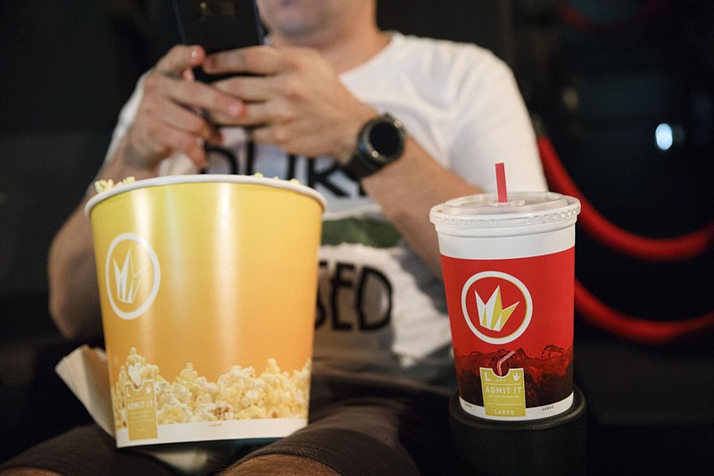 An audience member sits with a soft drink cup and popcorn tub at the Regal Cinemas L.A. LIVE Stadium 14 movie theater in Los Angeles. MUST CREDIT: Bloomberg photo by Patrick T. Fallon