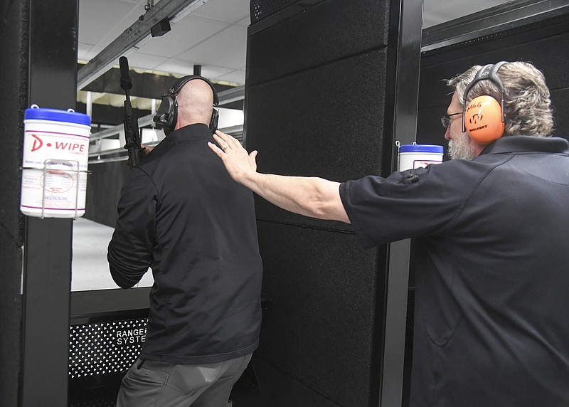 Under Sheriff Jason Lawrence prepares to fire a machine gun at the Machine Gun Grotto, 325 Olive St., on Sunday. - Photo by Grace Brown of The Sentinel-Record