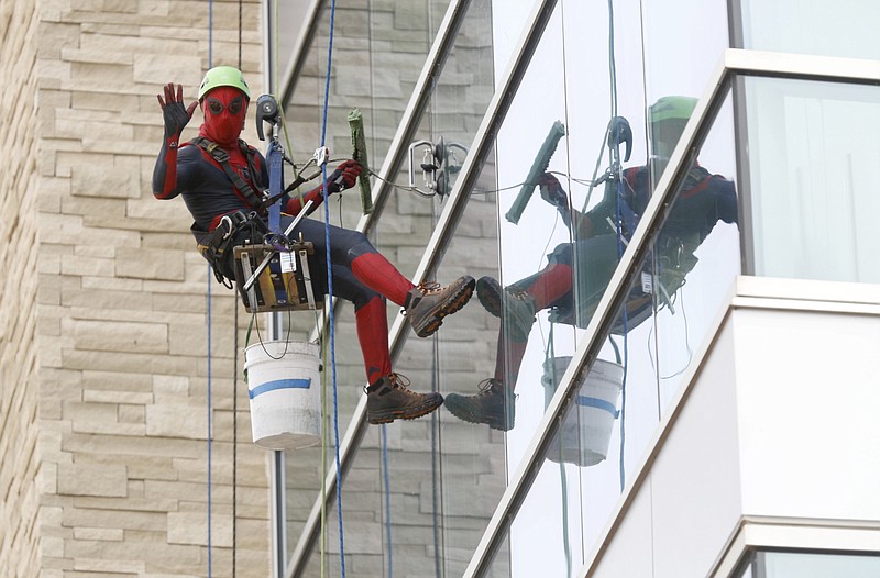 Chris Berryhill, owner of Berryhill Window Cleaning, works in a Spiderman costume Monday as he cleans with Corbin Carlisle, in costume as Iron Man, a section of the Arkansas Children's Northwest in Springdale. The company cleans the windows every three months and dresses up as superheroes for the children when they look outside of their windows. Check out nwaonline.com/210323Daily/ and nwadg.com/photos for a photo gallery.
(NWA Democrat-Gazette/David Gottschalk)