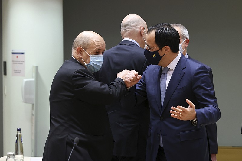 French Foreign Minister Jean-Yves Le Drian, left, talks to Cypriot Foreign Minister Nikos Christodoulides during a European Foreign Affairs Ministers meeting at the European Council headquarters in Brussels, Monday, March 22, 2021. (Aris Oikonomou, Pool Photo via AP)