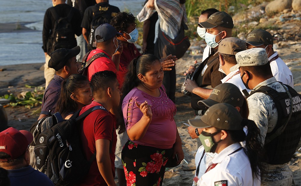 Mexican immigration agents stop people who crossed the Suchiate River, the natural border between Guatemala and Mexico, to see their identification documents as they enforce limits on all but essential travel near Ciudad Hidalgo, Mexico, Monday, March 22, 2021. Agents are forcing those with permission to enter Mexico for work or a visit to use the official border crossing bridge and others are being returned to Guatemala. (AP Photo/Eduardo Verdugo)