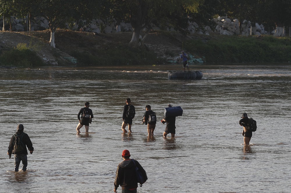 Guatemalan travelers return to Tecun Uman, Guatemala as they wade across the Suchiate River, the natural border between Guatemala and Mexico after they were turned away by Mexican immigration agents near Ciudad Hidalgo, Mexico, Monday, March 22, 2021. Agents are forcing those with permission to enter Mexico for work or a visit to use the official border crossing bridge and those who do not are being returned to Guatemala, as they enforce new limits on all but essential travel at its shared border with Guatemala. (AP Photo/Eduardo Verdugo)