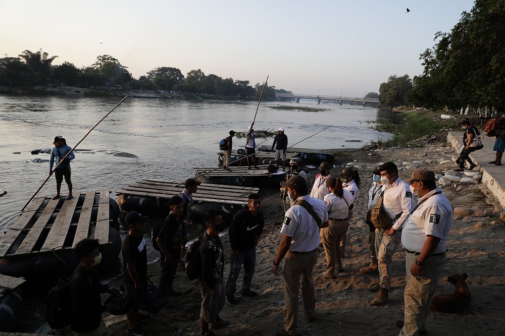 Mexican immigration agents stop people who crossed the Suchiate River, the natural border between Guatemala and Mexico, to see their identification documents near Ciudad Hidalgo, Mexico, Monday, March 22, 2021. Agents are forcing those with permission to enter Mexico for work or a visit to use the official border crossing bridge, and those who do not are being returned to Guatemala, as they enforce new limits on all but essential travel at its shared border with Guatemala. (AP Photo/Eduardo Verdugo)