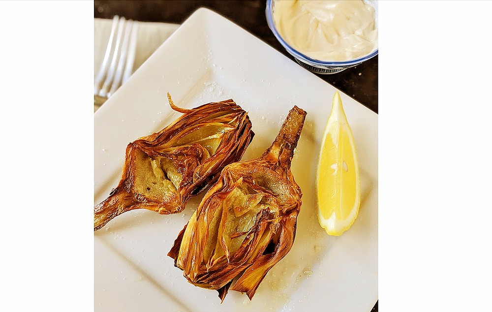 Artichokes halves fried in olive oil can be served with mayonnaise for dipping and wedges of fresh lemon. (TNS/Post-Gazette/Gretchen McKay)