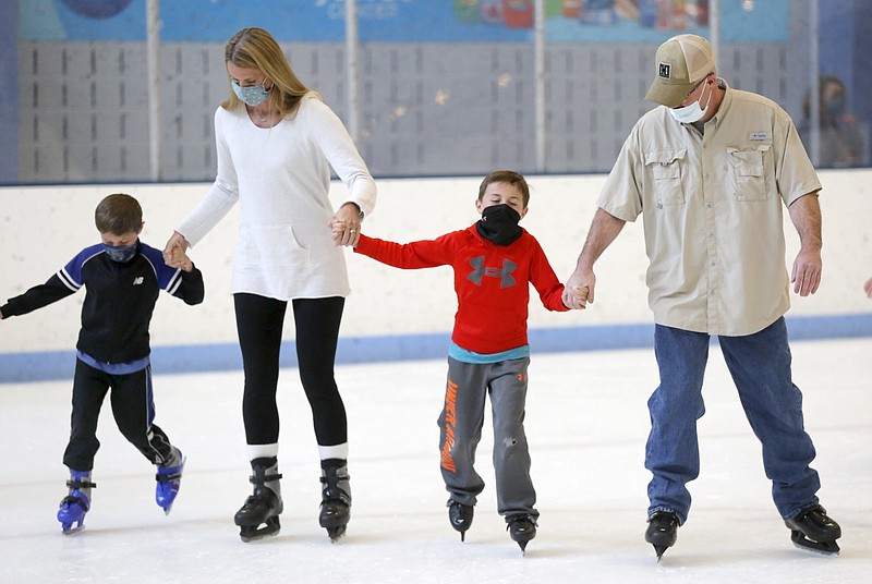Brittany Taylor skates with her sons Mason (left), 5, Grayson, 7, and her brother Chad Myers Tuesday during Spring Break Skate Camp at the Jones Center in Springdale. The Jones Center is offering Spring Break activities that includes swimming, ice skating, music, movies and other special events. More information can be found at thejonescenter.net. 
(NWA Democrat-Gazette/David Gottschalk)