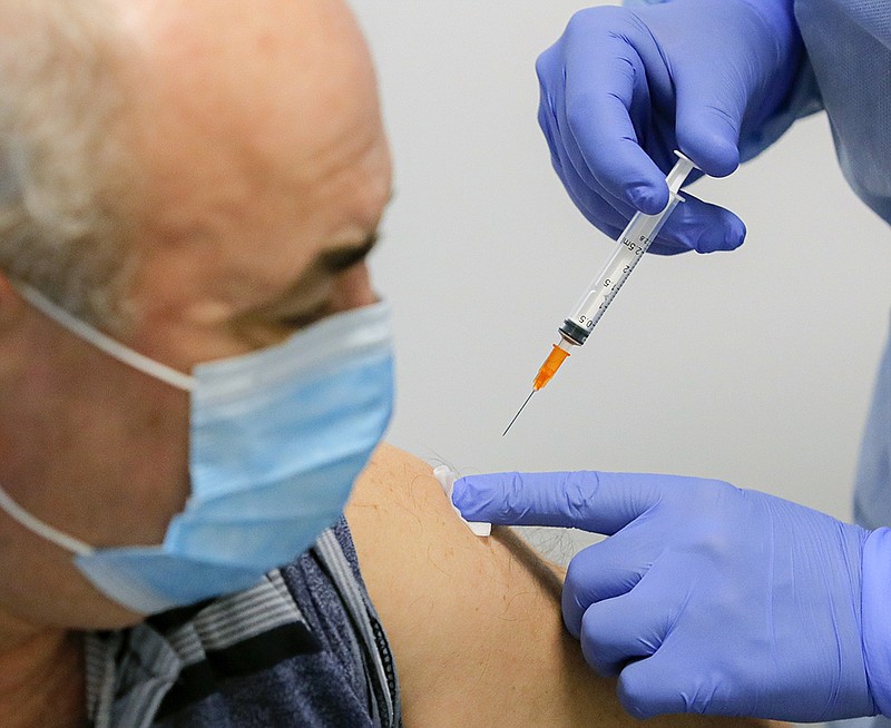 A man gets a AstraZeneca vaccine at a vaccination center that offers both AstraZeneca and Pfizer vaccines in Bucharest, Romania, Tuesday, March 23, 2021. AstraZeneca's repeated missteps in reporting vaccine data coupled with a blood clot scare could do lasting damage to the credibility of a shot that is the linchpin in the global strategy to stop the coronavirus pandemic, potentially even undermining vaccine confidence more broadly, experts say.(AP Photo/Vadim Ghirda)