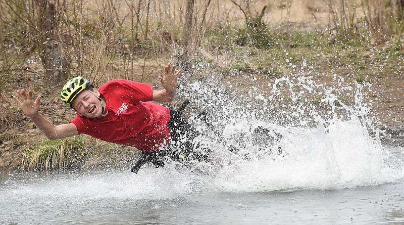 Hap Hall is ejected from his bike into Lee Creek at high speed April 6, 2019, during the big splash contest of the 31st annual Ozark Mountain Bike Festival at Devil’s Den State Park. (NWA Democrat-Gazette file photo/Flip Putthoff)