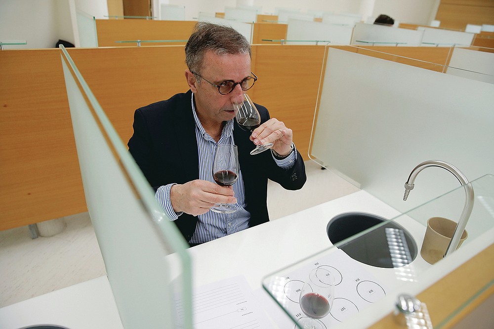 Bordeaux Mayor Pierre Hurmic smells glasses of wine, during a tasting session, with one glass containing wine that spent a year orbiting the world in the International Space Station, at the Institute for Wine and Vine Research in Villenave-d'Ornon, southwestern France, Monday, March 1, 2021. Researchers in Bordeaux are carefully studying a dozen bottles of French wine that returned to Earth after a stay aboard the International Space Station. They’re releasing preliminary results Wednesday, March 24, 2021. At a one-of-a-kind tasting this month, 12 connoisseurs sampled one of the space-traveled wines, blindly tasting it alongside a bottle from the same vintage that had stayed in a cellar. (AP Photo/Christophe Ena)
