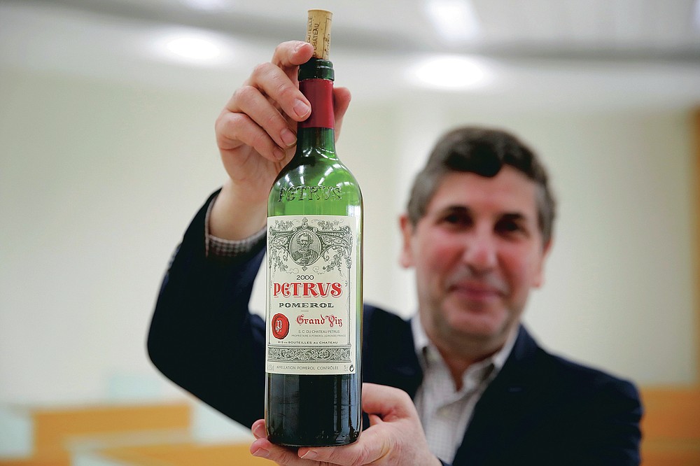 Philippe Darriet, president of the Institute for Wine and Vine Research (ISVV )and chief oenologist holds a bottle of Petrus red wine that spent a year orbiting the world in the International Space Station after a tasting session at the ISVV in Villenave-d'Ornon, southwestern France, Monday, March 1, 2021. Researchers in Bordeaux are carefully studying a dozen bottles of French wine that returned to Earth after a stay aboard the International Space Station. They’re releasing preliminary results Wednesday, March 24, 2021. At a one-of-a-kind tasting this month, 12 connoisseurs sampled one of the space-traveled wines, blindly tasting it alongside a bottle from the same vintage that had stayed in a cellar. (AP Photo/Christophe Ena)