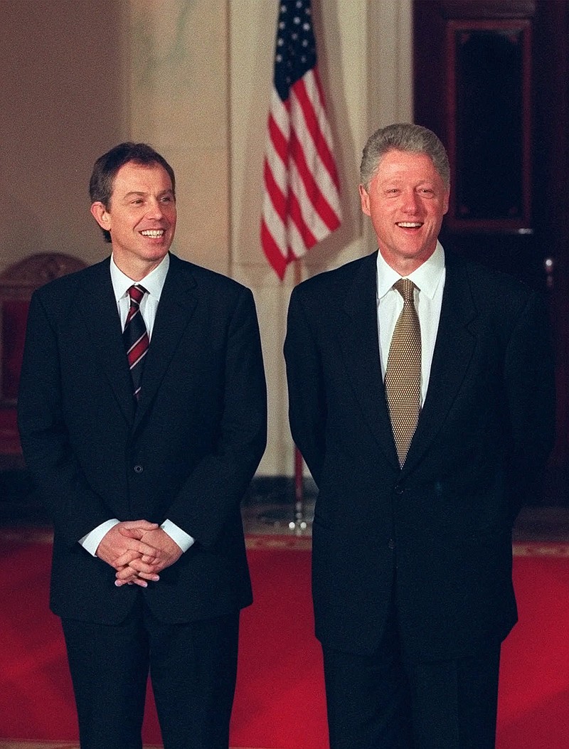 FILE - In this Feb. 5, 1998, file photo President Bill Clinton, right, and British Prime Minister Tony Blair stand during a welcoming ceremony for Blair at the White House in Washington. On Feb. 6, 1988, during a Clinton news conference he was asked at what point he might decide the crisis was too much to put his family through anymore and resign. “Never," he said, stone-faced. (AP Photo/J. Scott Applewhite, File)