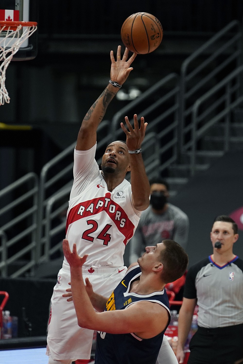 Toronto Raptors forward Norman Powell (24) grabs a rebound over Denver Nuggets center Nikola Jokic (15) during the first half of an NBA basketball game Wednesday, March 24, 2021, in Tampa, Fla. (AP Photo/Chris O'Meara)