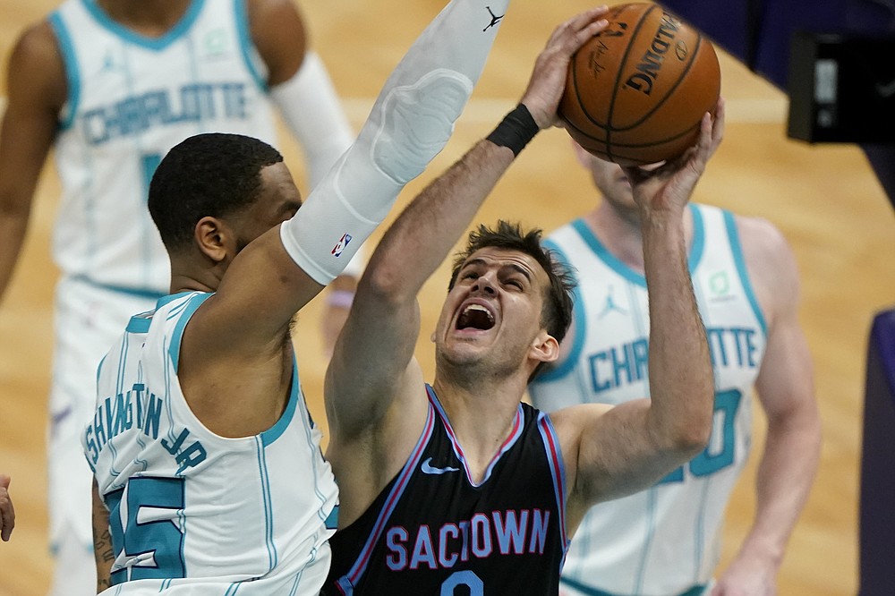 Sacramento Kings forward Nemanja Bjelica shoots over Charlotte Hornets forward P.J. Washington during the first half of an NBA basketball game on Monday, March 15, 2021, in Charlotte, N.C. (AP Photo/Chris Carlson)
