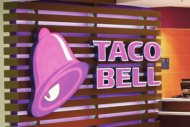 FILE - This Friday, April 19, 2019 photo shows a Taco Bell logo at a restaurant in Miami. On Friday, March 26, 2021, The Associated Press reported on social media posts circulating online incorrectly asserting Taco Bell is offering $60 and Walmart is offering $75 coupons to customers who share and comment on their posts. The posts come from Facebook accounts that at first glance appear to match the name and branding of each company, but actually claim to represent an “unofficial community page.” Representatives from both companies confirmed the posts are not real. (AP Photo/Wilfredo Lee)