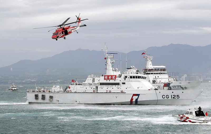 FILE - In this May 4, 2019, file photo, Taiwan Coast Guard ships and a helicopter take part in a search-and-rescue operation during an offshore anti-terrorism drill at a harbor in New Taipei City, Taiwan. China on Friday denounced an agreement between the U.S. and Taiwanese coast guards that underscores growing ties between Washington and the self-governing island democracy. (AP Photo/Chiang Ying-ying, File)