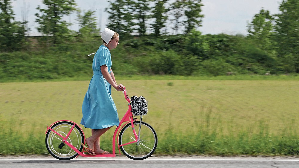 An Amish girl rides her scooter, Wednesday, May 27, 2020, near Middlefield, Ohio. (AP Photo/Tony Dejak)