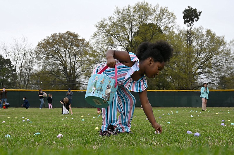 Alaysia Kennedy, 5, picks up eggs scattered through the baseball field during an Easter egg hunt at Excell Park in Jacksonville on Saturday, March 27, 2021. Kids were separated by age group, and each hunt had over 2,000 eggs to find, including some with tickets for special prizes hidden inside. See more photos at arkansasonline.com/328eggs/

(Arkansas Democrat-Gazette/Stephen Swofford)