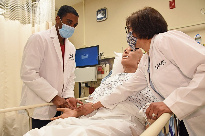 Dr. Sara Tariq, an associate professor in the Internal Medicine department at the University of Arkansas for Medical Sciences, helps Dakory Lee, a UAMS medical student, find the pulse on a medical simulation mannequin Wednesday, March 24, 2021 at UAMS Medical Center in Little Rock.
(Arkansas Democrat-Gazette/Staci Vandagriff)