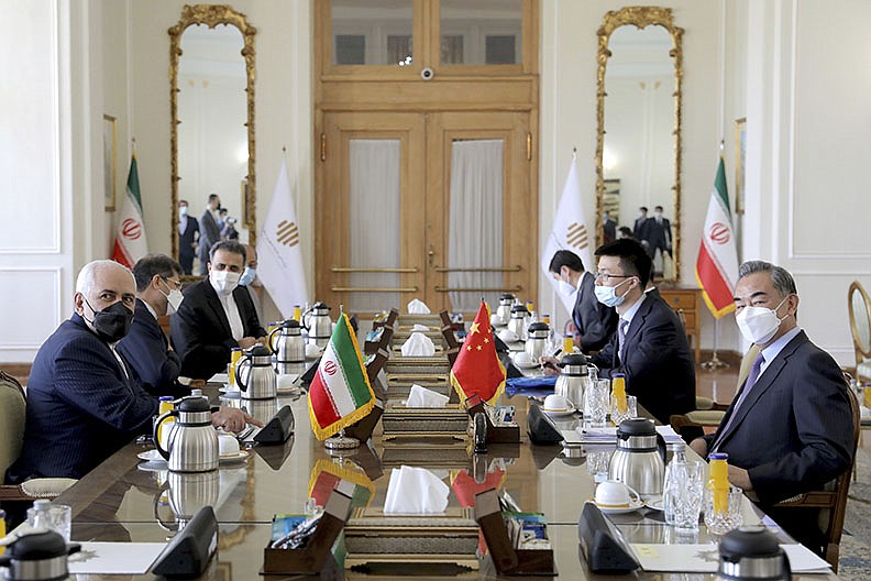 Iranian Foreign Minister Mohammad Javad Zarif, left, and his Chinese counterpart Wang Yi, right, attend a meeting, in Tehran, Iran, Saturday, March 27, 2021. Iran and China on Saturday signed a 25-year strategic cooperation agreement addressing economic issues amid crippling U.S. sanctions on Iran, state TV reported. (AP Photo/Ebrahim Noroozi)
