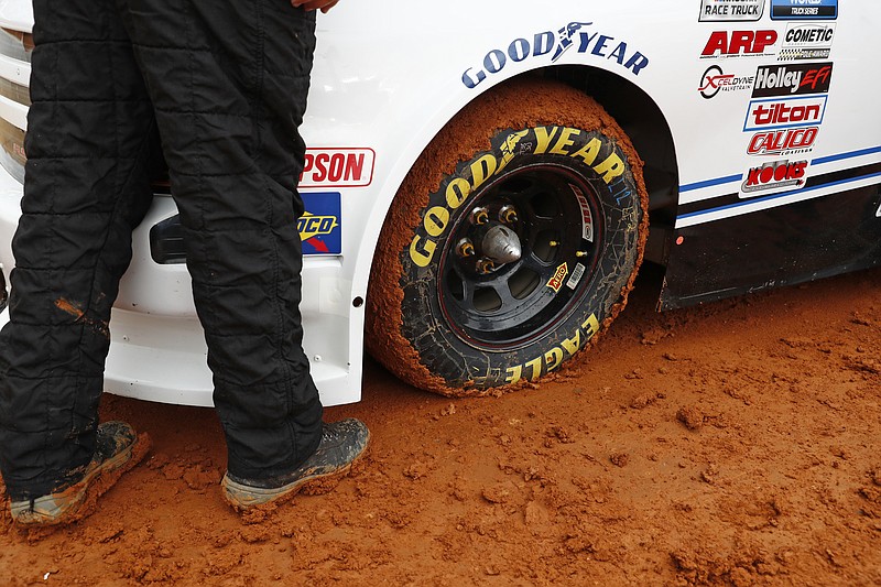 Mud stick to the tire of a truck as it prepares to compete in a heat race for a NASCAR Truck Series race on Saturday, March 27, 2021, in Bristol, Tenn. (AP Photo/Wade Payne)