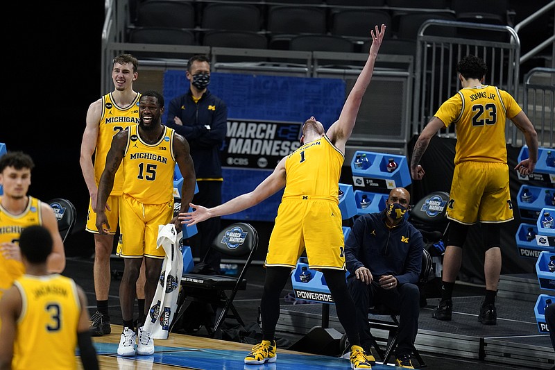 Michigan center Hunter Dickinson (1) celebrates with teammates at the end of a Sweet 16 game against Florida State in the NCAA men's college basketball tournament at Bankers Life Fieldhouse, Sunday, March 28, 2021, in Indianapolis. Michigan won 76-58. (AP Photo/Jeff Roberson)