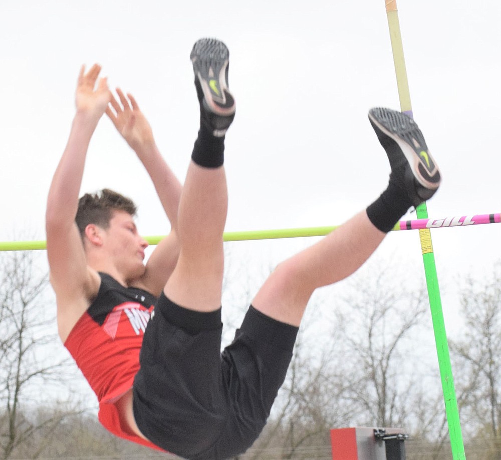 RICK PECK/SPECIAL TO MCDONALD COUNTY PRESS McDonald County's Andrew Watkins clears the bar on the way to a third place finish in the pole vault at the Stancell McDonald County Stampede held on March 25, at McDonald County High School.
