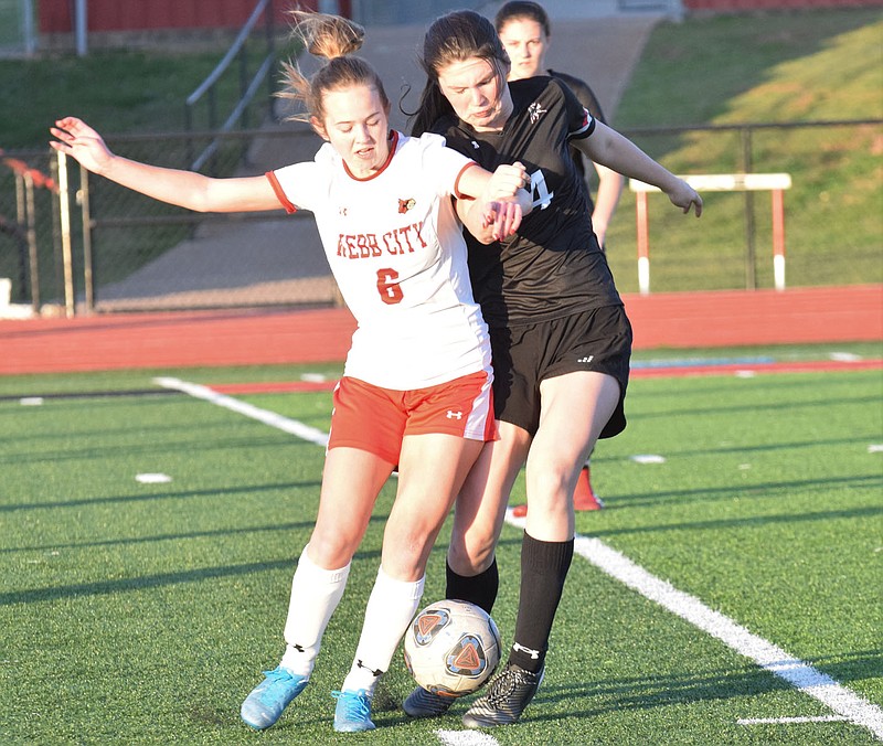RICK PECK/SPECIAL TO MCDONALD COUNTY PRESS McDonald County's Anna Clarkson battles with a Webb City defender for control of the ball during the Lady Mustangs' 8-0 loss on March 26 at McDonald County High School.