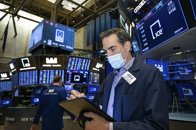 In this photo provided by the New York Stock Exchange, trader Gregory Rowe works on the trading floor, Monday, March 29, 2021. U.S. stocks stabilized in afternoon trading and hovered near the record highs they set last week, but losses for big banks tempered gains. (Nicole Pereira/New York Stock Exchange via AP)