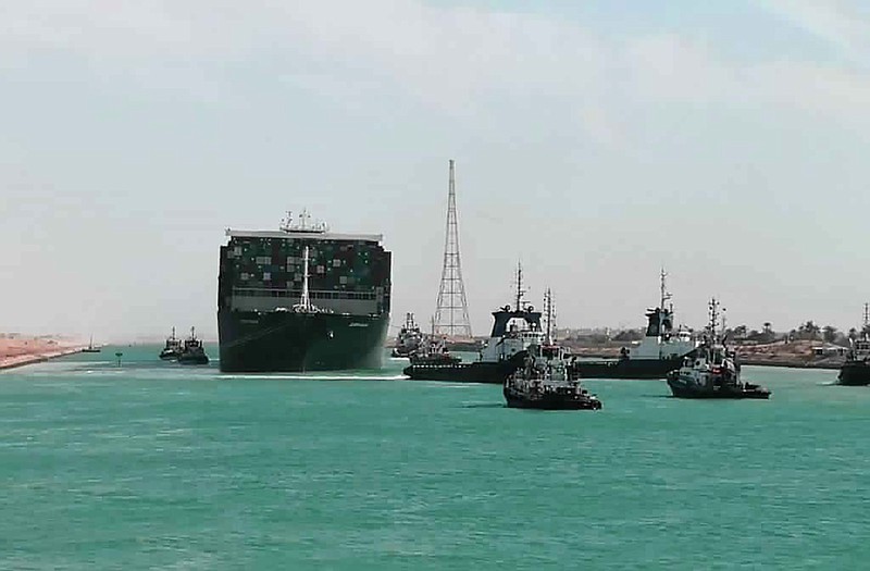 In this photo released by Suez Canal Authority, the Ever Given, a Panama-flagged cargo ship is accompanied by Suez Canal tugboats as it moves in the Suez Canal, Egypt, Monday, March 29, 2021. Salvage teams on Monday set free a colossal container ship that has halted global trade through the Suez Canal, bringing an end to a crisis that for nearly a week had clogged one of the world’s most vital maritime arteries. (Suez Canal Authority via AP)