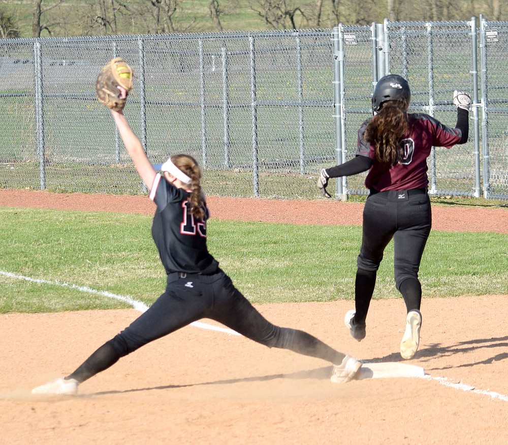 Westside Eagle Observer/MIKE ECKELS
Lady Lion Taylor Neustel (13 left) stretches as far as she can to catch a throw from Lizzy Ellis near third base during the second inning of the Gravette-Siloam Springs varsity softball contest in Gravette Thursday night. Neustel's effort paid off since the Lady Panther runner was called out a first base.