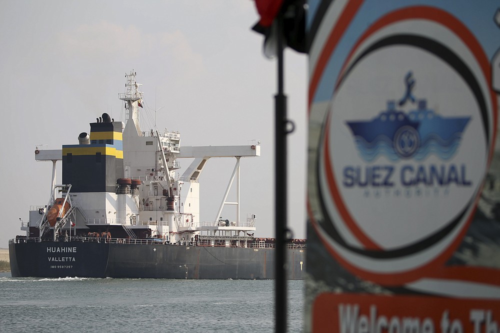 A cargo ship sails through the town of Ismailia, Egypt, Tuesday, March 30, 2021 as traffic resumed through the Suez canal after it was blocked by a massive ship that had been stuck sideways for nearly a week. (AP Photo/AP Photo/Ayman Aref))