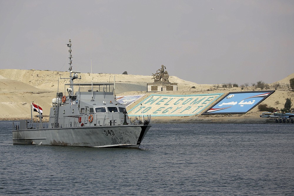 A cargo ship sails through the town of Ismailia, Egypt, Tuesday, March 30, 2021 as traffic resumed through the Suez canal after it was blocked by a massive ship that had been stuck sideways for nearly a week. (AP Photo/AP Photo/Ayman Aref))