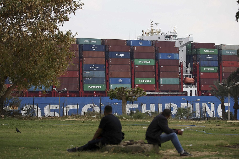 A cargo ship sails through the town of Ismailia, Egypt, Tuesday, March 30, 2021 as traffic resumed through the Suez canal after it was blocked by a massive ship that had been stuck sideways for nearly a week. (AP Photo/AP Photo/Ayman Aref))