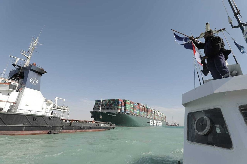 In this photo released by Suez Canal Authority, the Ever Given, a Panama-flagged cargo ship is accompanied by Suez Canal tugboats as it moves in the Suez Canal, Egypt, Monday, March 29, 2021. Salvage teams on Monday set free a colossal container ship that has halted global trade through the Suez Canal, bringing an end to a crisis that for nearly a week had clogged one of the world's most vital maritime arteries. (Suez Canal Authority via AP)