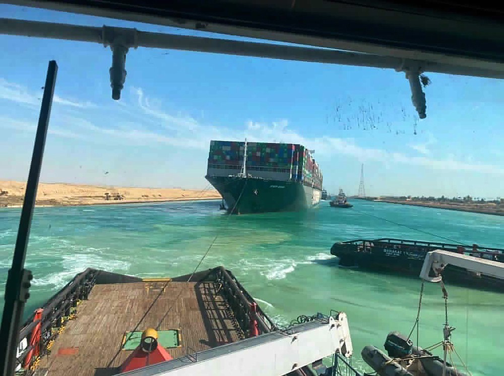 In this photo released by Suez Canal Authority, the Ever Given, a Panama-flagged cargo ship is accompanied by Suez Canal tugboats as it moves in the Suez Canal, Egypt, Monday, March 29, 2021. Salvage teams on Monday set free a colossal container ship that has halted global trade through the Suez Canal, bringing an end to a crisis that for nearly a week had clogged one of the world’s most vital maritime arteries. (Suez Canal Authority via AP)
