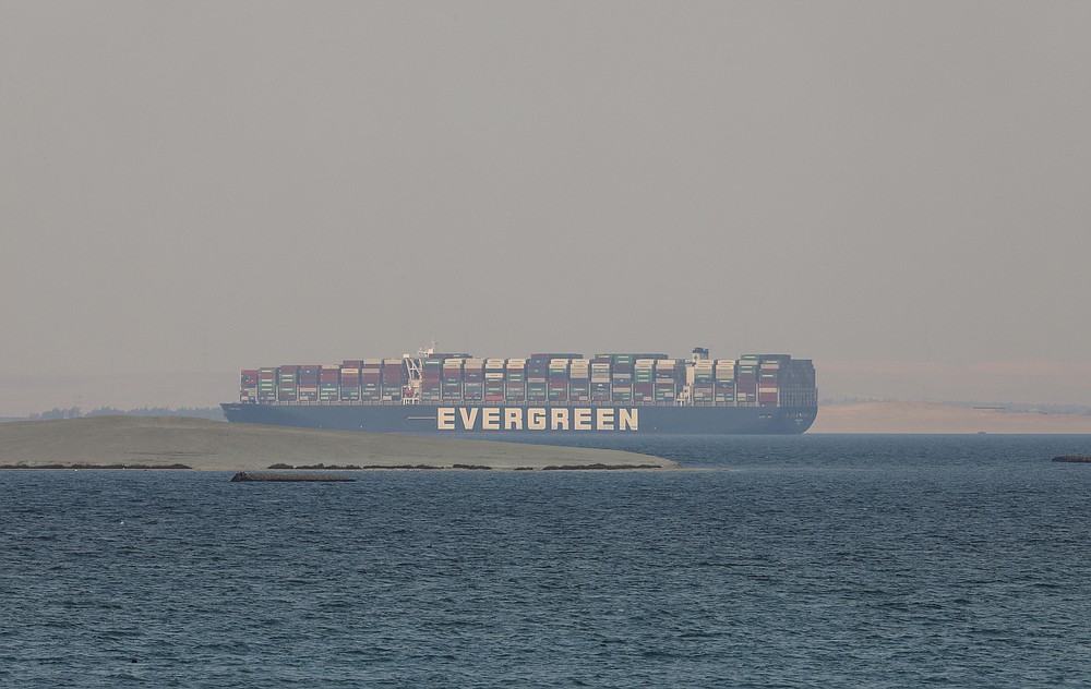 Ever Given, a Panama-flagged cargo ship, is seen in Egypt's Great Bitter Lake Tuesday, March 30, 2021. Experts have boarded Ever Given container ship that had blocked the Suez Canal for nearly a week before it was dislodged. A canal pilot says engineers are inspecting the Ever Given for damage and trying to determine why it ran aground. (AP Photo/Mohamed Elshahed)
