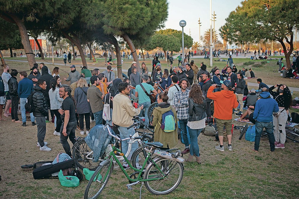Local people gather at a public park in Barcelona, Spain, Sunday, March 28, 2021. Efforts in Spain to restart tourism activity is drawing a mixed picture due to a patchwork of national, regional and European rules on travel that is confusing both tourists and their hosts. (AP Photo/Emilio Morenatti)