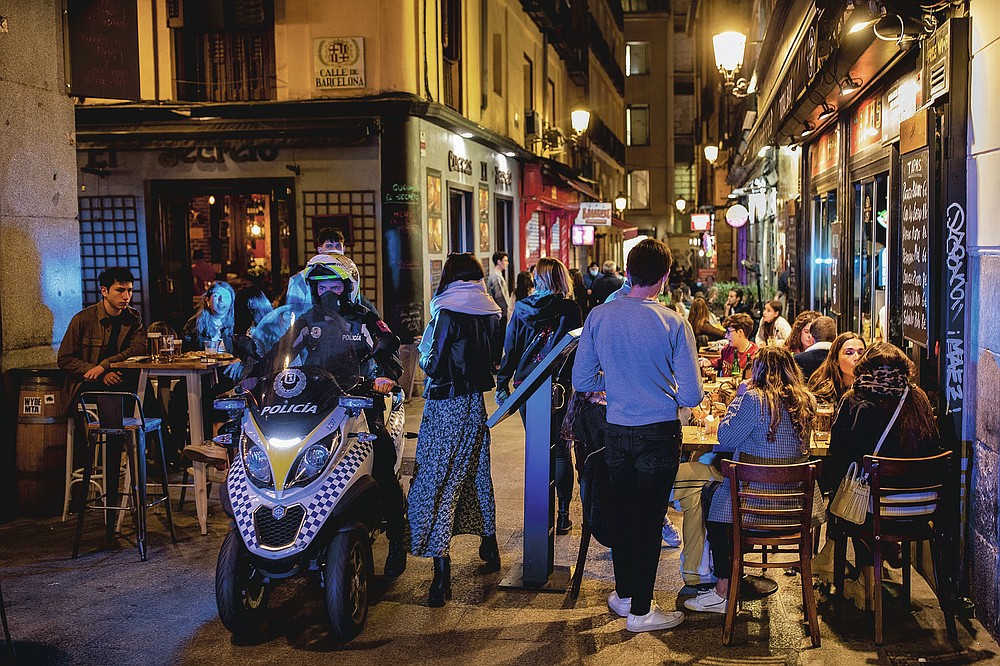 Policeman patrols in downtown Madrid, Spain, Friday, March 26, 2021. With its policy of open bars and restaurants — indoors and outdoors — and by keeping museums and theaters running even when outbreaks have strained hospitals, Madrid has built a reputation as an oasis of fun in Europe’s desert of restrictions. Other Spanish regions have a stricter approach to entertainment. Even sunny coastal resorts offer a limited range of options for the few visitors that started to arrive, coinciding with Easter week, amid a set of contradictory European travel rules. (AP Photo/Bernat Armangue)
