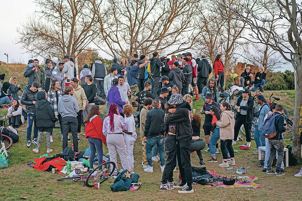 Local people gather at a public park in Barcelona, Spain, Sunday, March 28, 2021. Efforts in Spain to restart tourism activity is drawing a mixed picture due to a patchwork of national, regional and European rules on travel that is confusing both tourists and their hosts. (AP Photo/Emilio Morenatti)