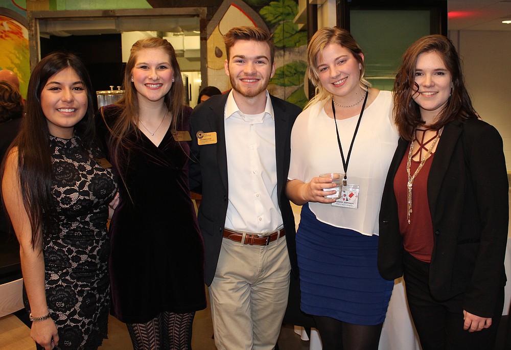 NWA Democrat-Gazette/CARIN SCHOPPMEYER Llanet Sanchez (from left), Katherine Leis, Benjamin Schaap, Katelin Johnson and Megan Butler, Northwest Arkansas Community College students, help welcome guests to the college's holiday reception Dec. 12 at Brightwater in Bentonville.