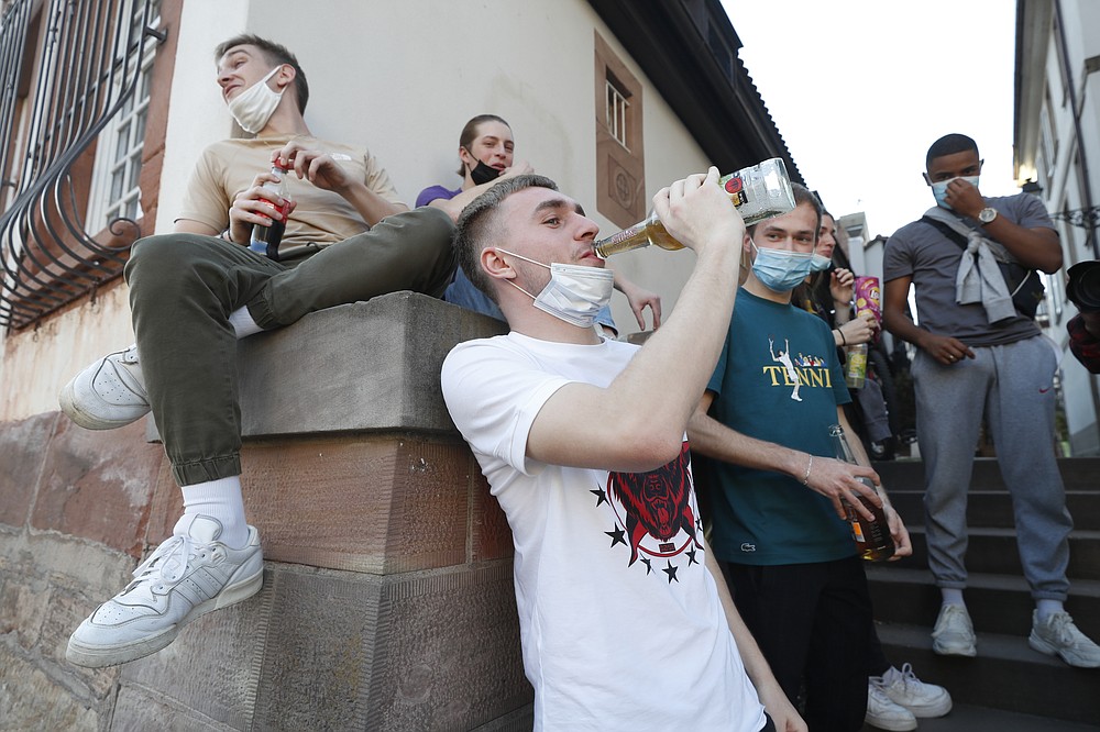 Youths gather during a sunny afternoon in Strasbourg, eastern France, Wednesday, March 31, 2021. French President Emmanuel Macron is expected to impose new virus restrictions in a televised address to the nation Wednesday night, amid growing pressure to act more boldly to combat surging coronavirus hospitalizations. (AP Photo/Jean-Francois Badias)