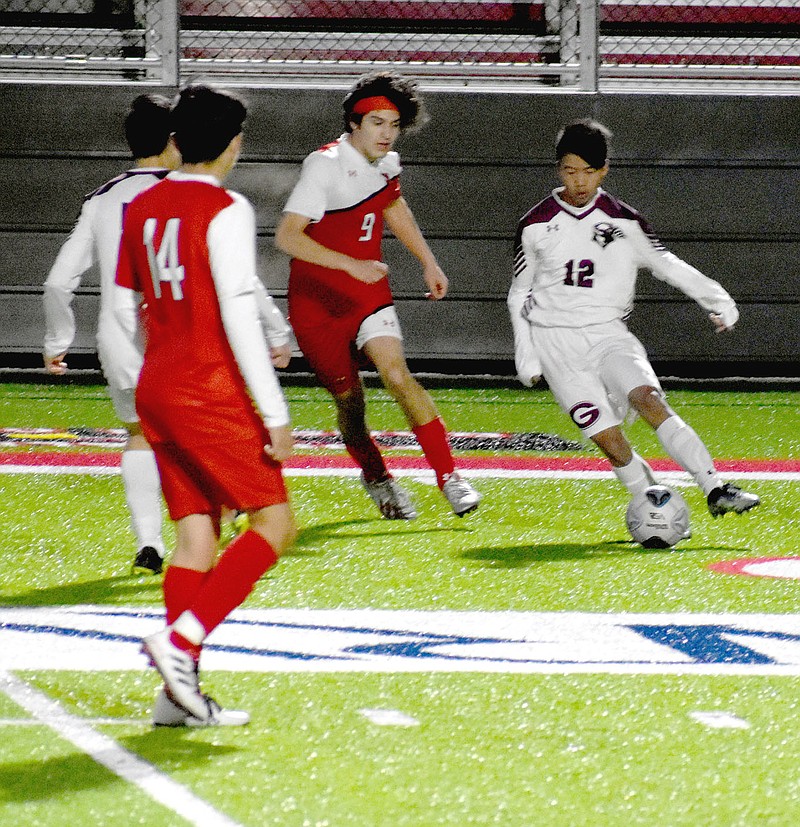 MARK HUMPHREY  ENTERPRISE-LEADER/Gentry sophomore Rayner Lee tries to maneuver between two Farmington players with a teammate running interference. The Pioneers lost 7-2 at Cardinal Stadium on Monday, March 29.