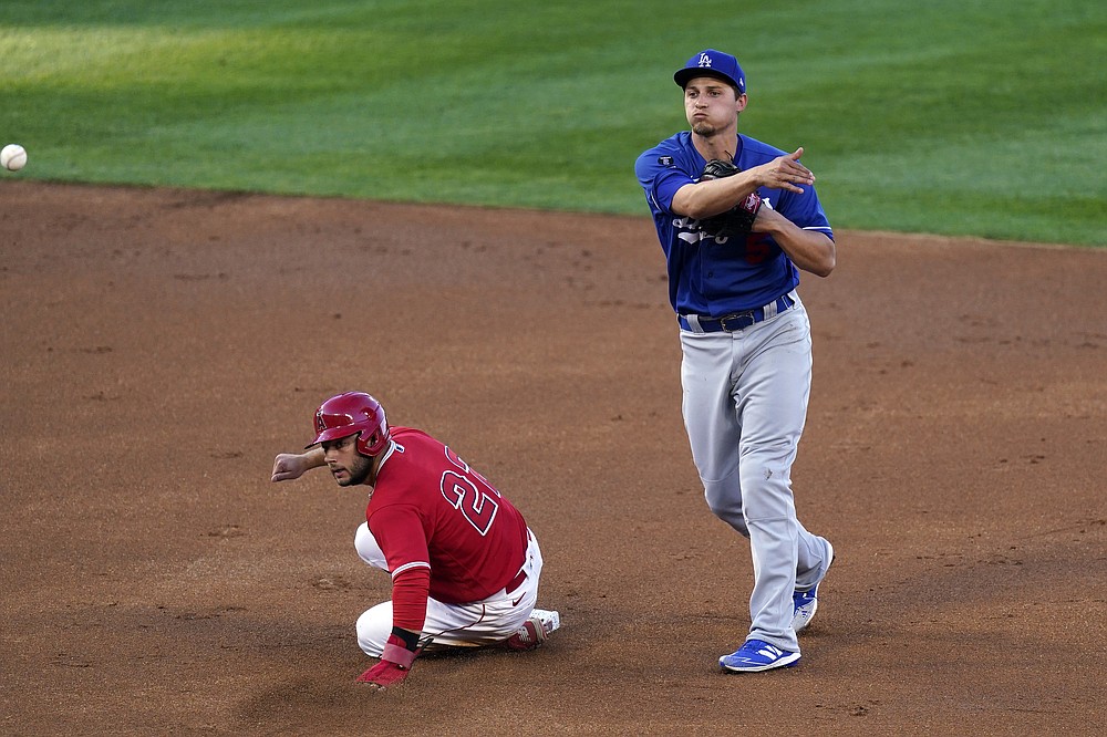 Los Angeles Angels' David Fletcher, left, is forced out at second as Los Angeles Dodgers shortstop Corey Seager attempts to throw out Jared Walsh at first during the first inning of a spring training exhibition baseball game Sunday, March 28, 2021, in Anaheim, Calif. Walsh was safe at first on the play. (AP Photo/Mark J. Terrill)