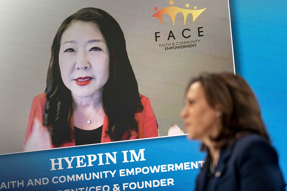 Faith and Community Empowerment President, CEO, and Founder Hyepin Im is displayed on a monitor behind Vice President Kamala Harris as she speaks during a virtual meeting with community leaders to discuss COVID-19 public education efforts in the South Court Auditorium in the Eisenhower Executive Office Building on the White House Campus, Thursday, April 1, 2021, in Washington. (AP Photo/Andrew Harnik)