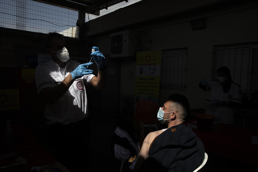FILE - In this March 8, 2021, file photo, Palestinian worker who works in Israel receives a Moderna COVID-19 vaccine at the Tarkumiya crossing between the West Bank and Israel. While the vast majority of the 100,000 or so Palestinians who live in the West Bank and have Israeli work permits have been vaccinated, immunization drives in the West Bank itself and Gaza have lagged far behind.
(AP Photo/Sebastian Scheiner, File)